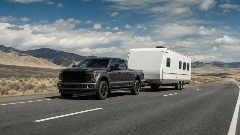 A pickup towing a travel trailer on a desert highway