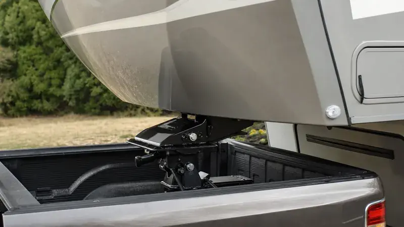 The nose of a fifth-wheel trailer above a pickup bed