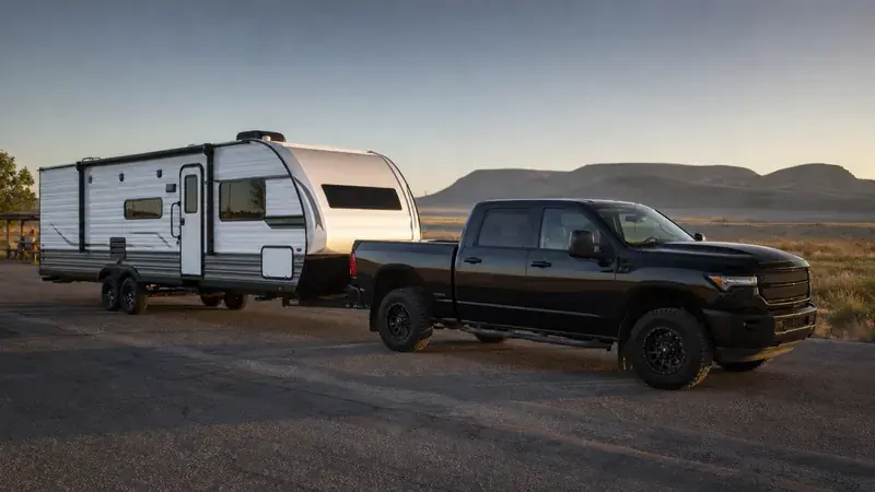 A pickup and travel trailer parked at dusk