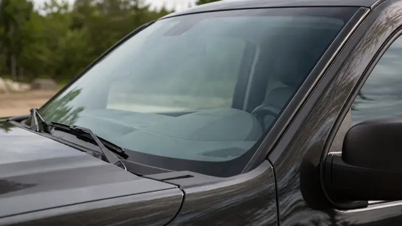 A pickup's windshield and dashboard seen from outside