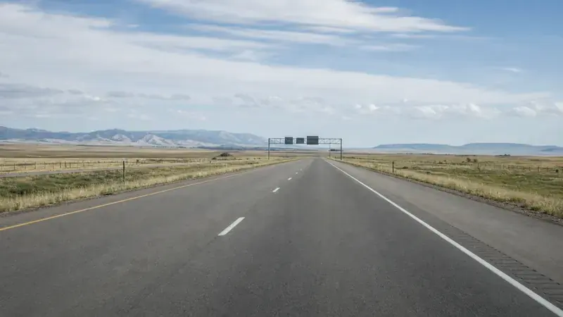An empty interstate with an overhead sign gantry