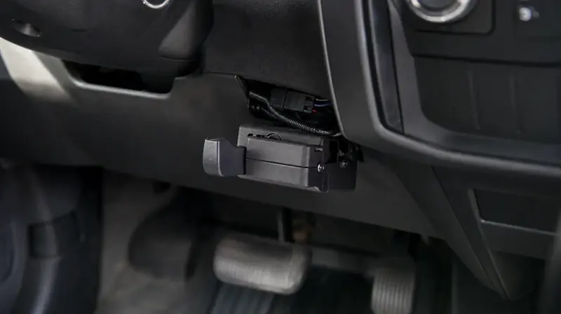 A trailer brake controller mounted under a pickup's dashboard