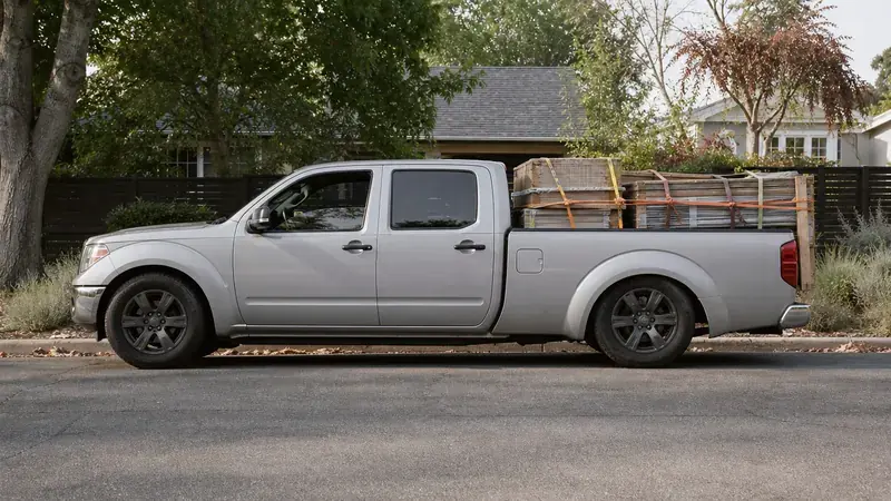 A pickup carrying a stack of lumber in its bed