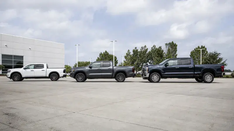 Three pickups parked outside a dealership